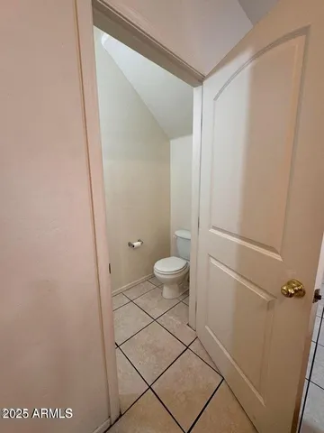 a bathroom with a granite countertop sink and a toilet