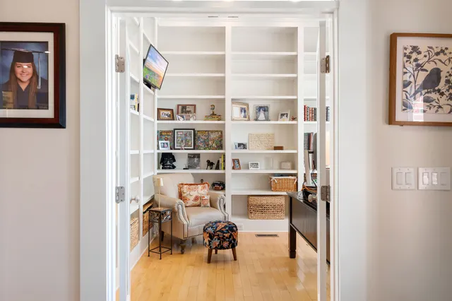 a view of a livingroom with workspace and a bookshelf