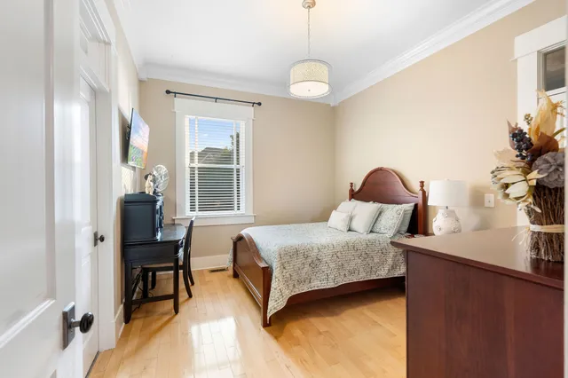 a bedroom with a bed and a chair with the potted plant