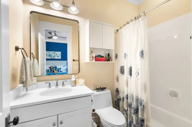 a bathroom with a sink a toilet and shower curtain