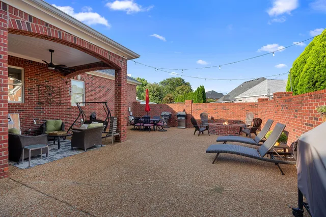 a backyard of a house with barbeque oven table and chairs