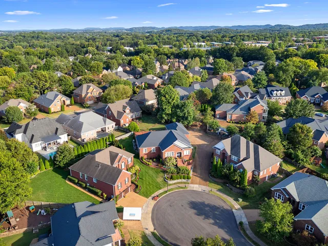 an aerial view of residential houses with outdoor space and parking