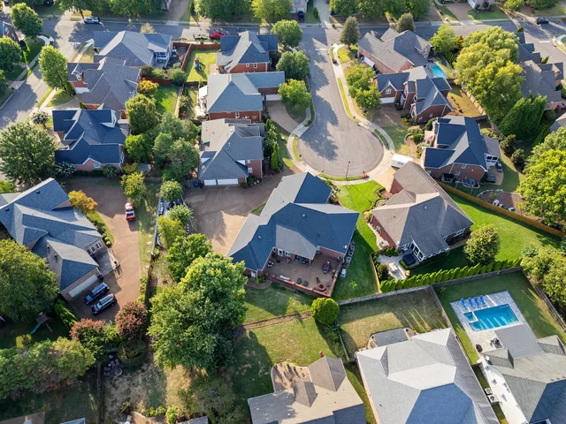 an aerial view of residential house with yard and swimming pool