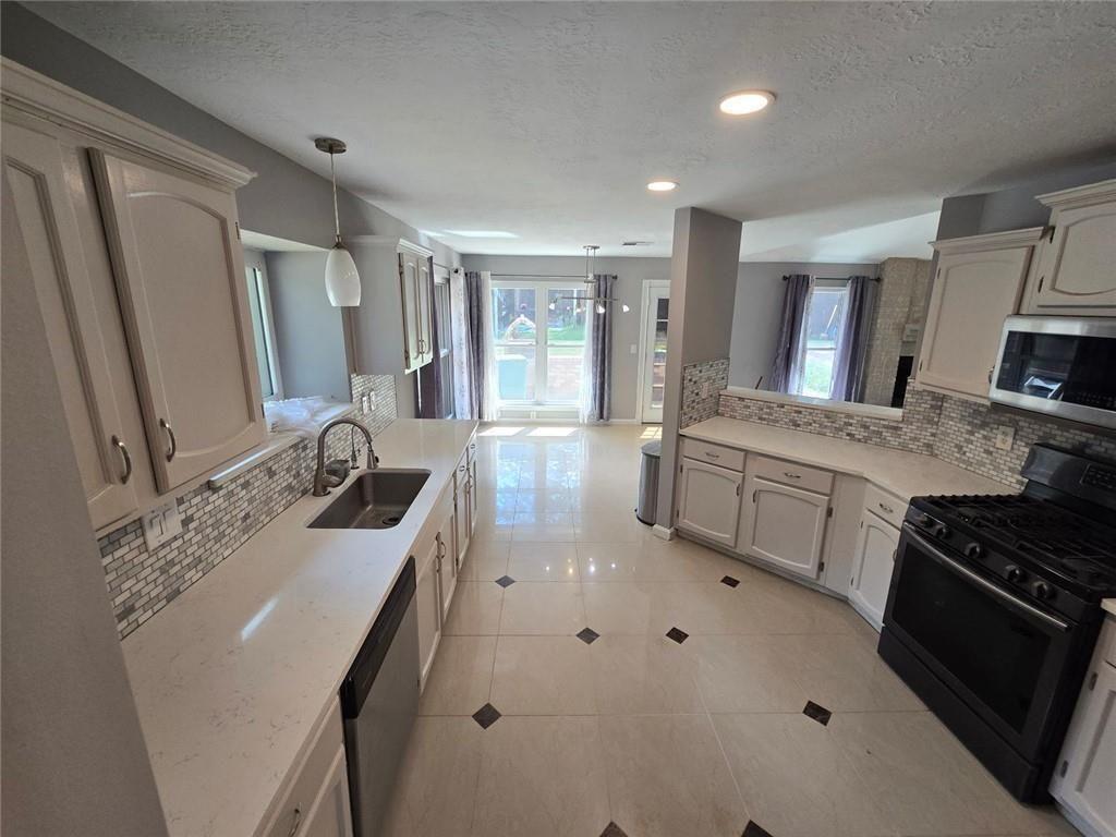 6992 Ivy Pointe Row Austell, GA 30168 - Photo 11 of 30 a kitchen with a sink stove and cabinets