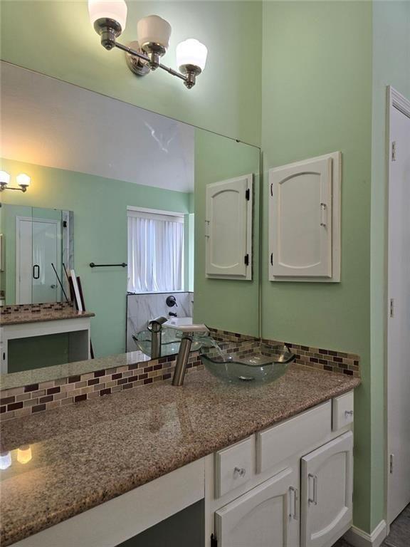 6992 Ivy Pointe Row Austell, GA 30168 - Photo 22 of 30 a bathroom with a granite countertop sink and a mirror