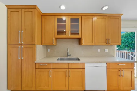 a kitchen with stainless steel appliances granite countertop white cabinets and a refrigerator