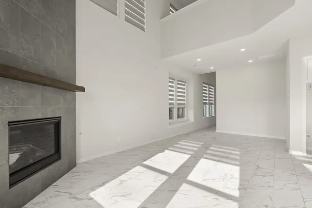 a view of an empty room with a fireplace and a window