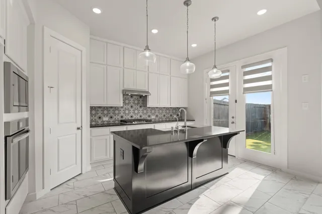 a kitchen with stainless steel appliances granite countertop a stove a sink and a refrigerator