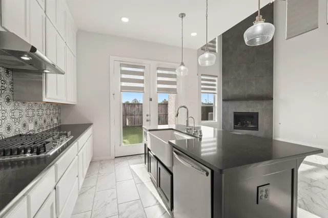 a kitchen with stainless steel appliances granite countertop a stove a sink and a refrigerator