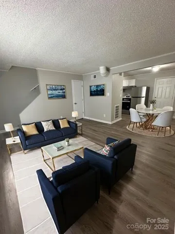 a living room with furniture and a wooden floor