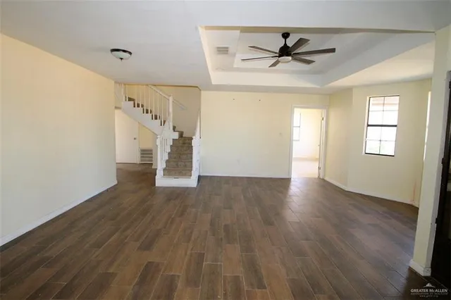 a view of a livingroom with wooden floor and a ceiling fan