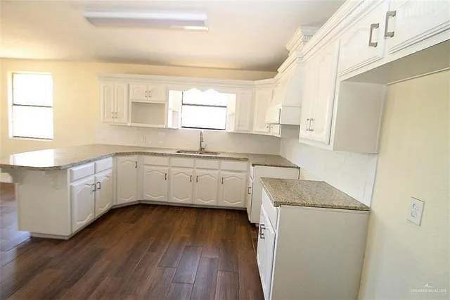 a kitchen with a sink a window a counter space and cabinets