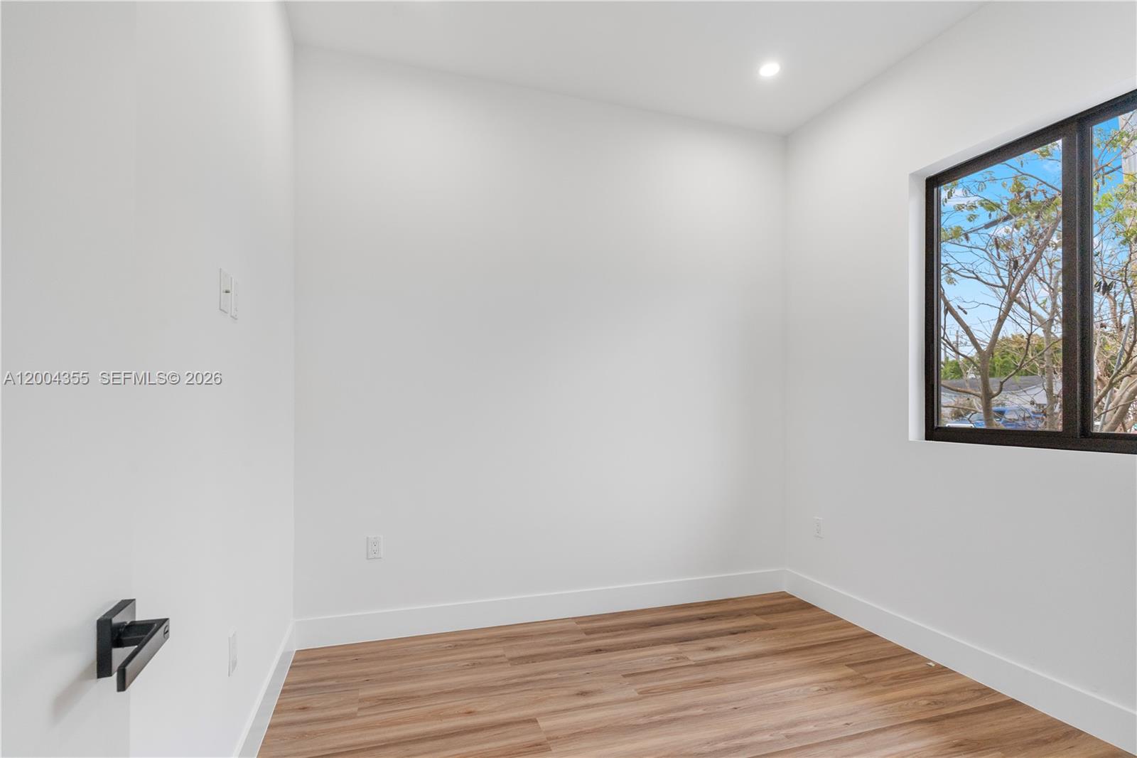 4518 Northwest 4th Street Miami, FL 33126 - Photo 14 of 23 a view of an empty room with wooden floor and window
