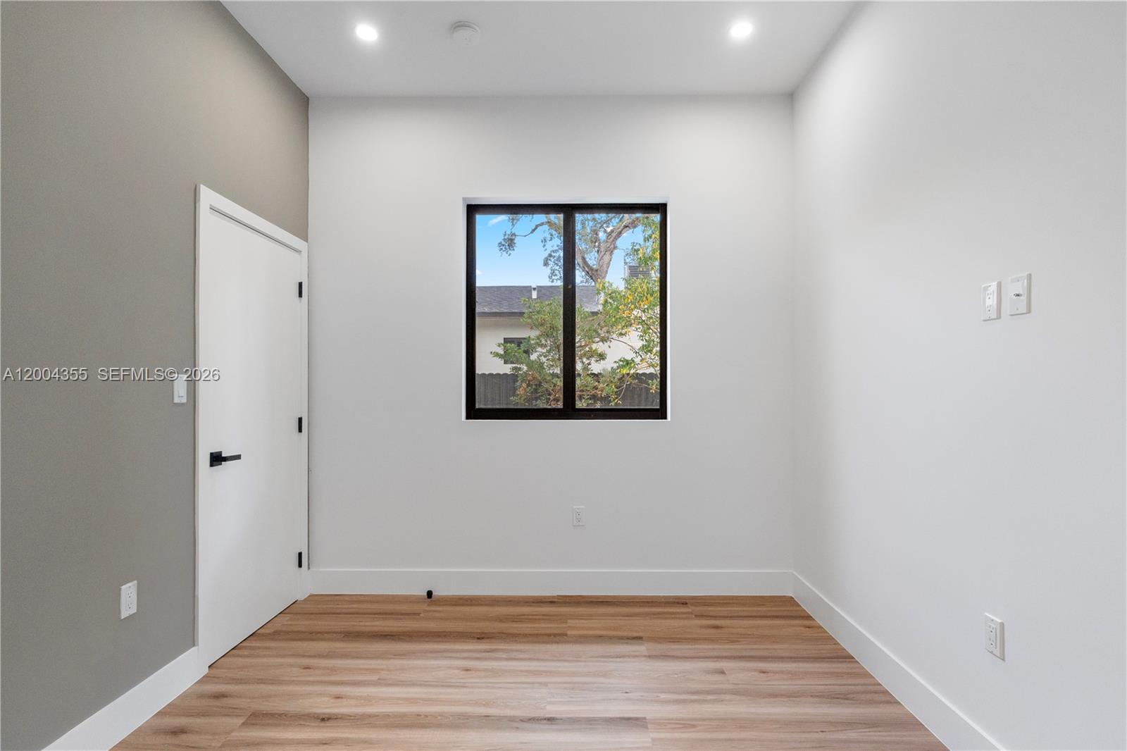4518 Northwest 4th Street Miami, FL 33126 - Photo 15 of 23 a view of an empty room with wooden floor and a window