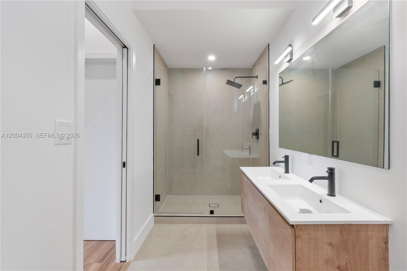 4518 Northwest 4th Street Miami, FL 33126 - Photo 9 of 23 a bathroom with a double vanity sink mirror and shower