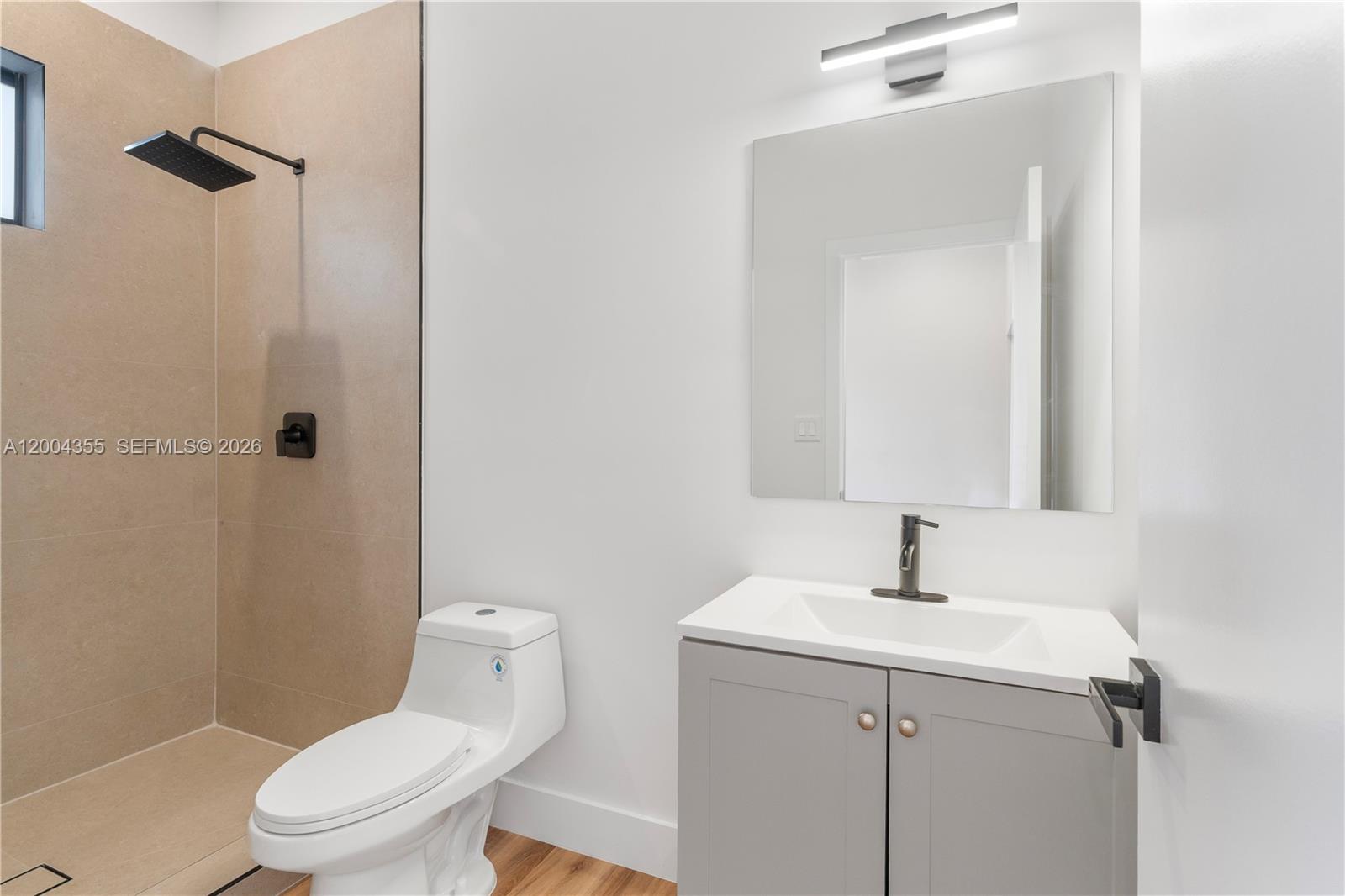 4518 Northwest 4th Street Miami, FL 33126 - Photo 10 of 23 a bathroom with a sink a toilet and a mirror