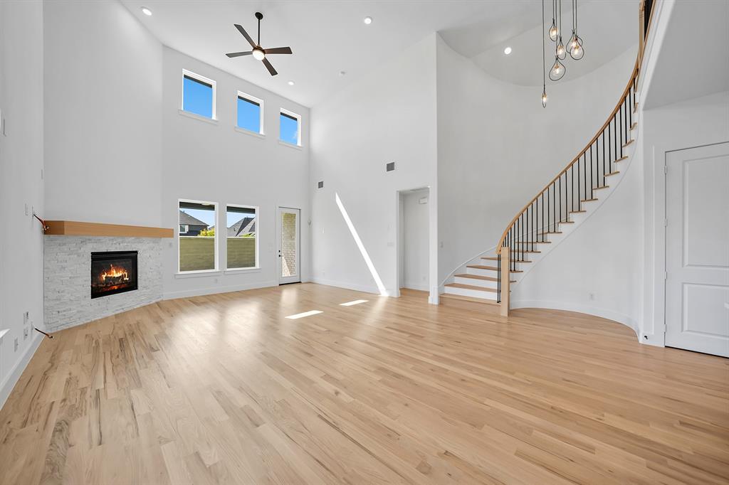 587 Mayfair Lane Frisco, TX 75033 - Photo 13 of 37 a view of an empty room with wooden floor fireplace and a window