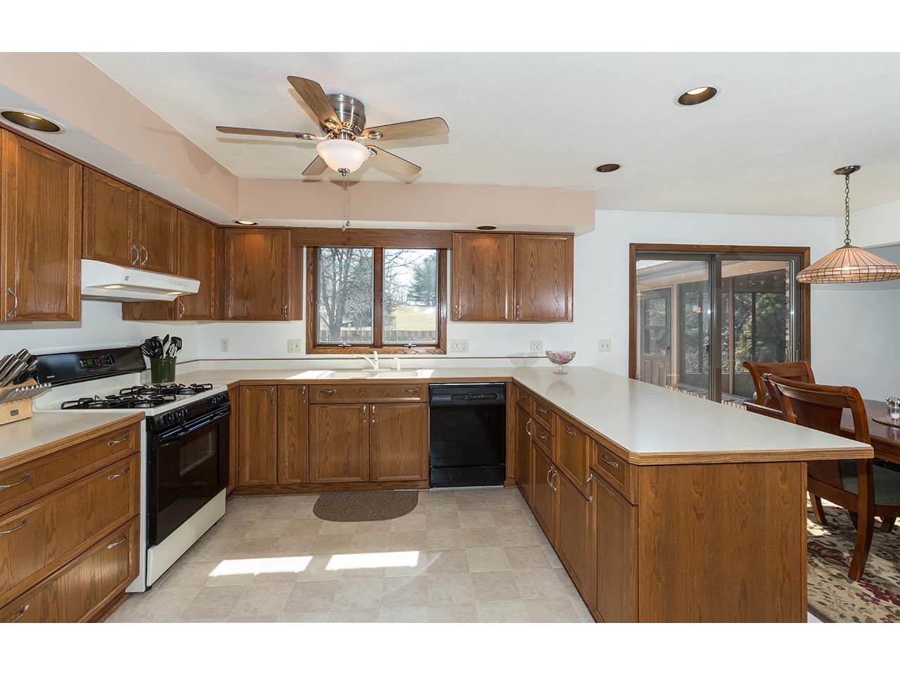 4571 East Marrill Road Byron, IL 61010 - Photo 5 of 25 a large kitchen with a stove a sink dishwasher a dining table and chairs with wooden floor