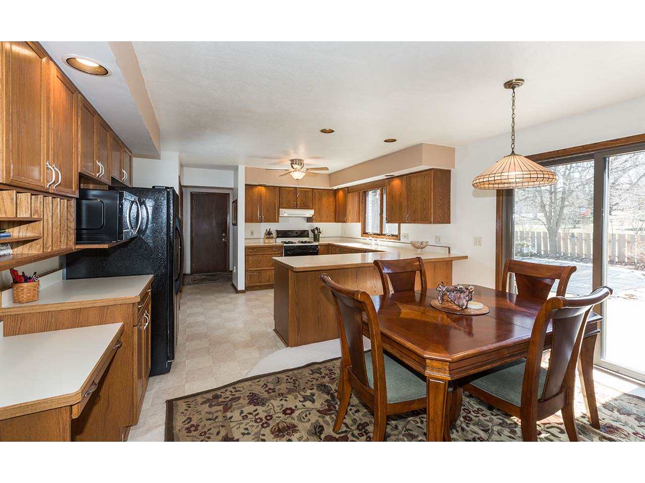 4571 East Marrill Road Byron, IL 61010 - Photo 7 of 25 a open kitchen with stainless steel appliances kitchen island granite countertop a table chairs and a refrigerator