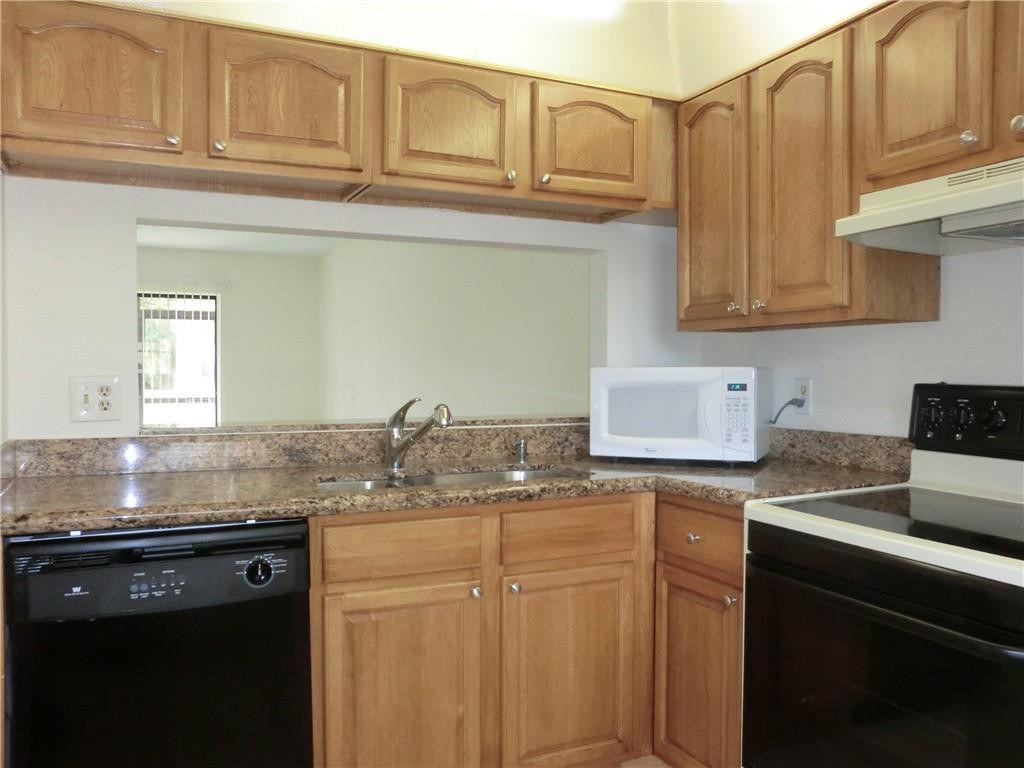 6796 Palmetto Circle South, Unit 101 Boca Raton, FL 33433 - Photo 11 of 29 a kitchen with granite countertop a sink stainless steel appliances and cabinets