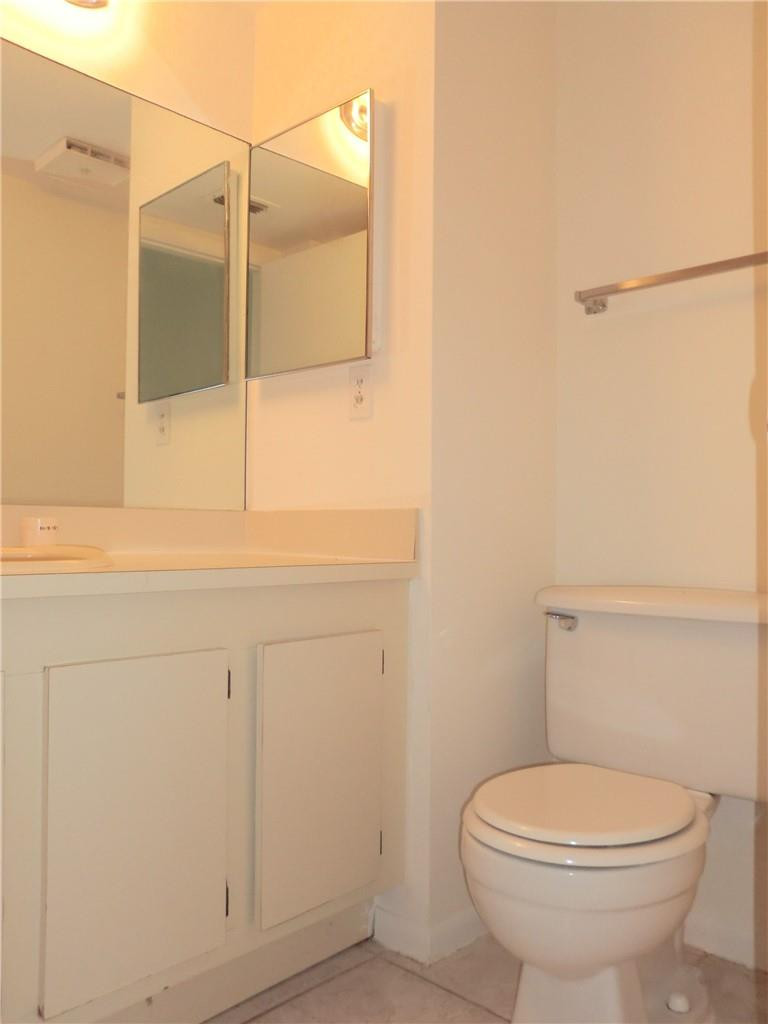 6796 Palmetto Circle South, Unit 101 Boca Raton, FL 33433 - Photo 16 of 29 a bathroom with a toilet a sink and shower