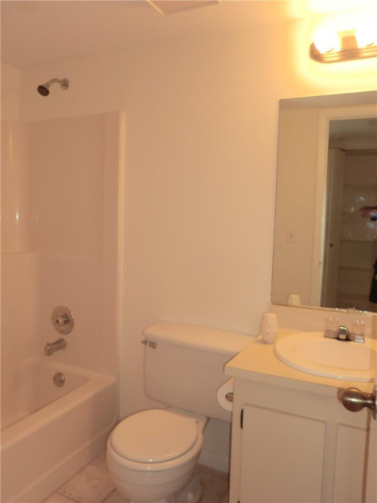 6796 Palmetto Circle South, Unit 101 Boca Raton, FL 33433 - Photo 21 of 29 a bathroom with a sink a toilet and bathtub
