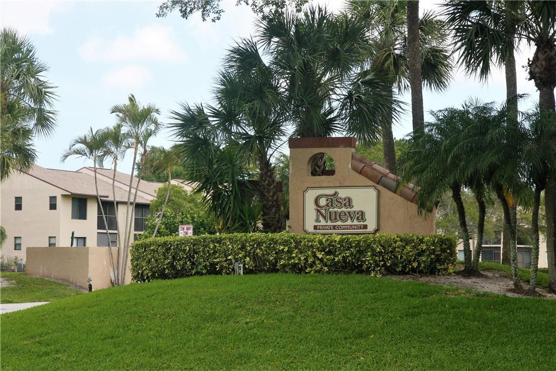 6796 Palmetto Circle South, Unit 101 Boca Raton, FL 33433 - Photo 23 of 29 a view of a white house with a yard and potted plants