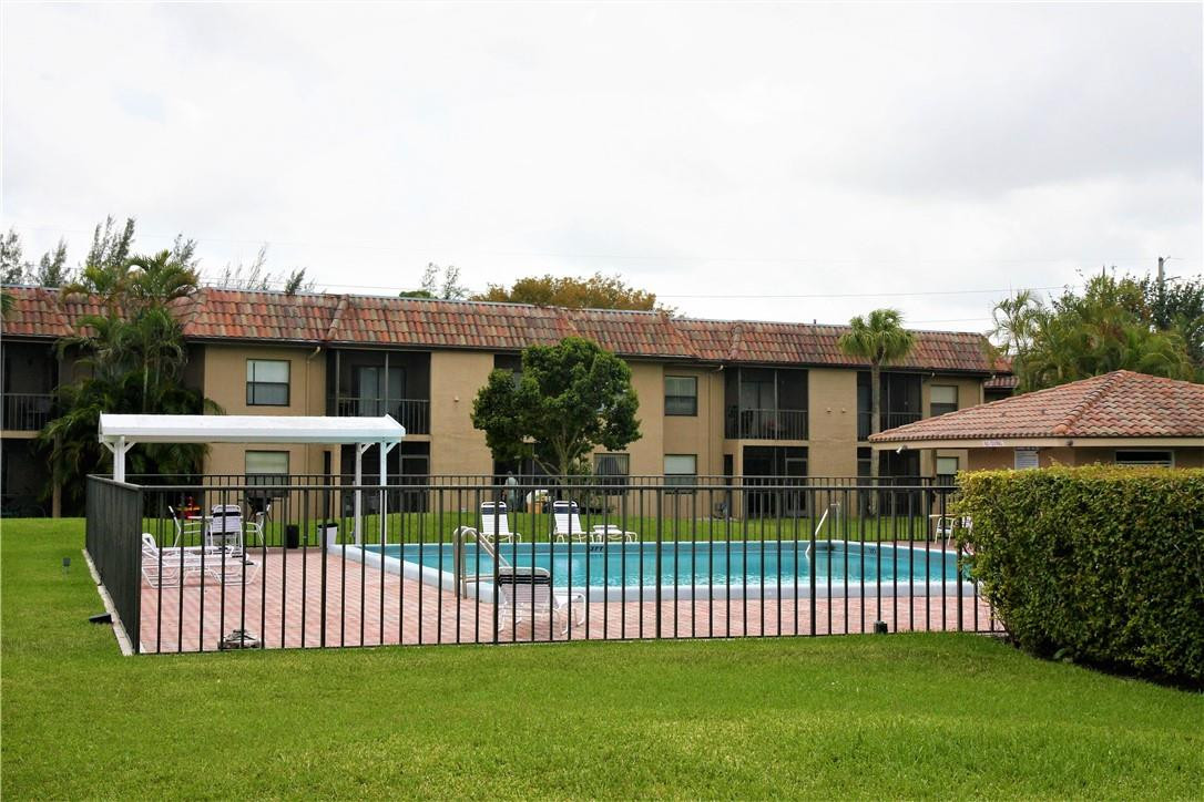 6796 Palmetto Circle South, Unit 101 Boca Raton, FL 33433 - Photo 25 of 29 a front view of a house with a garden