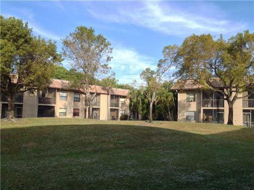 6796 Palmetto Circle South, Unit 101 Boca Raton, FL 33433 - Photo 4 of 29 a front view of a building with a garden