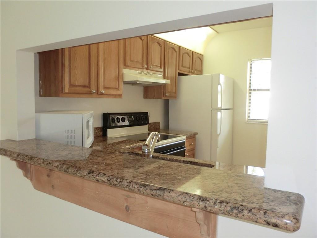 6796 Palmetto Circle South, Unit 101 Boca Raton, FL 33433 - Photo 7 of 29 a kitchen with a refrigerator a stove and a cabinets