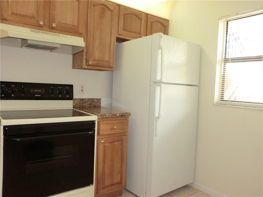 6796 Palmetto Circle South, Unit 101 Boca Raton, FL 33433 - Photo 9 of 29 a white refrigerator freezer sitting inside of a kitchen