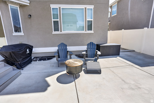 2178 Autumn Drive Mapleton, UT 84664 - Photo 39 of 48 Concrete patio area with a privacy fence, exterior lighting, and a basement window well