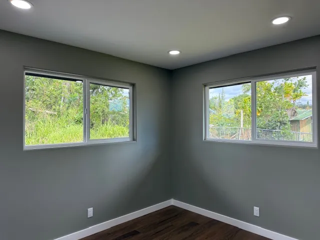 a view of a big room with wooden floor and windows