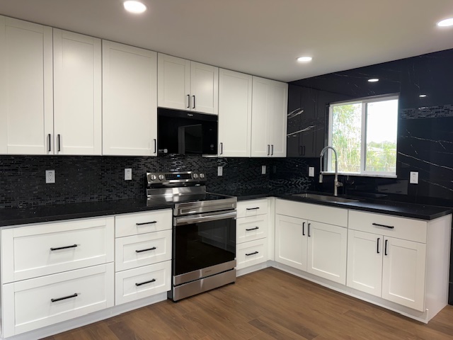 144 Chong Street Hilo, HI 96720 - Photo 2 of 28 a kitchen with granite countertop white cabinets and black appliances