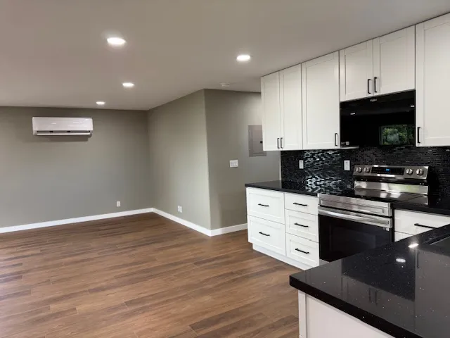 a kitchen with stainless steel appliances kitchen island granite countertop a stove a sink and a microwave