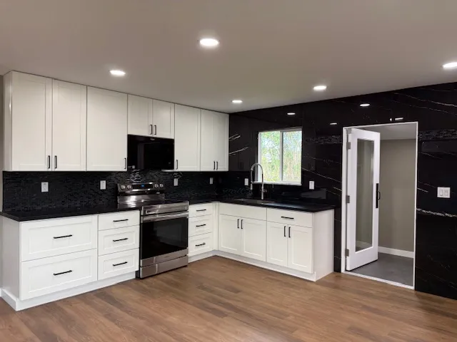 a kitchen with granite countertop a sink and a stove top oven