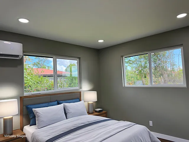 a bedroom with a bed and a large window