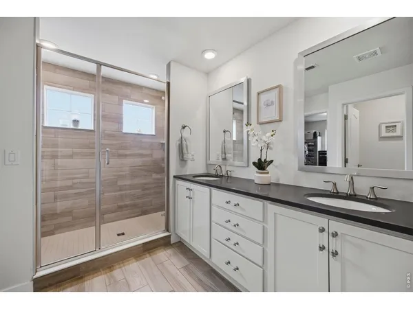 a bathroom with a shower sink and mirror