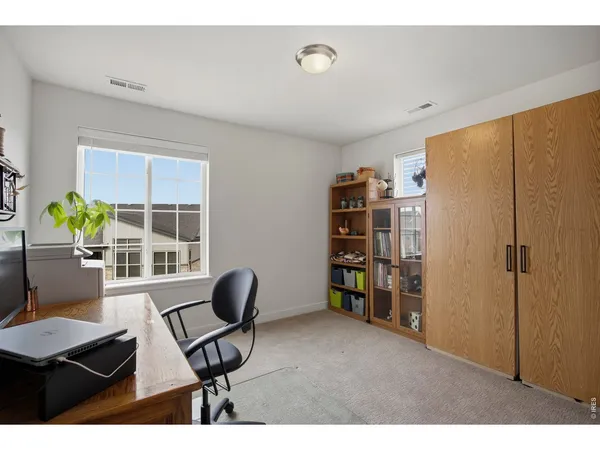 a view of a workspace with furniture and a window