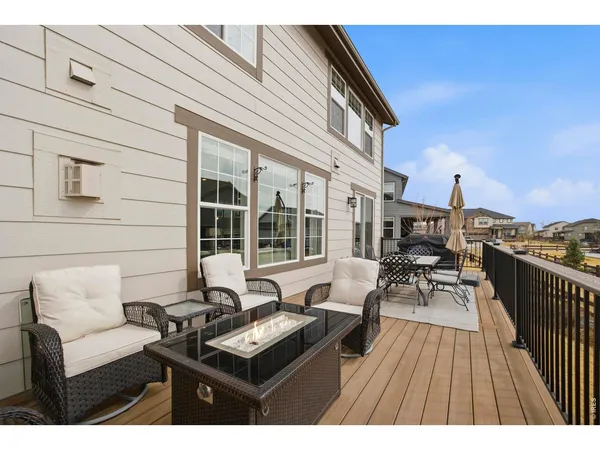 a roof deck with couches and wooden floor