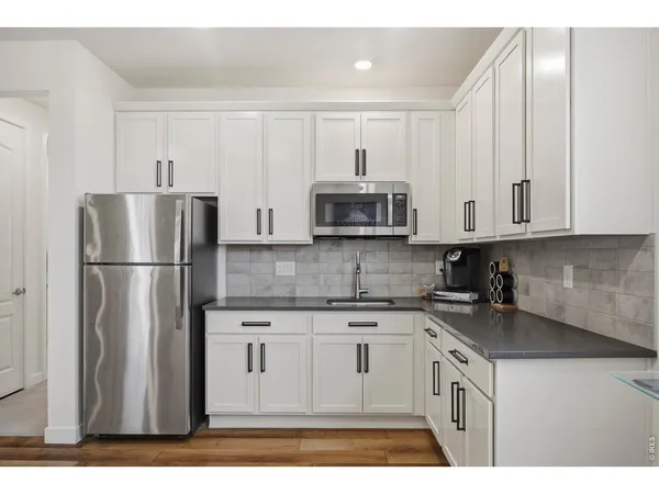 a kitchen with stainless steel appliances granite countertop a refrigerator sink and microwave