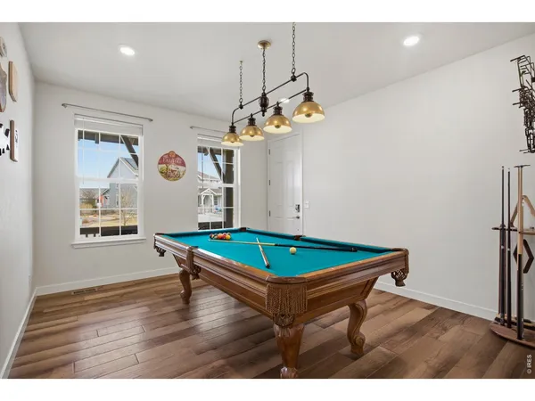 a room with pool table and windows