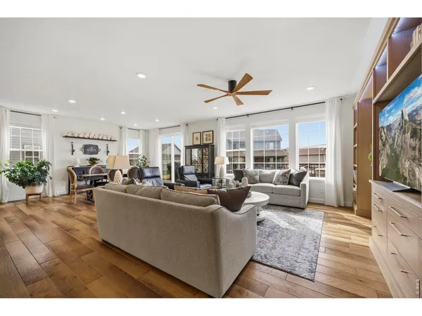 a living room with furniture kitchen view and a large window