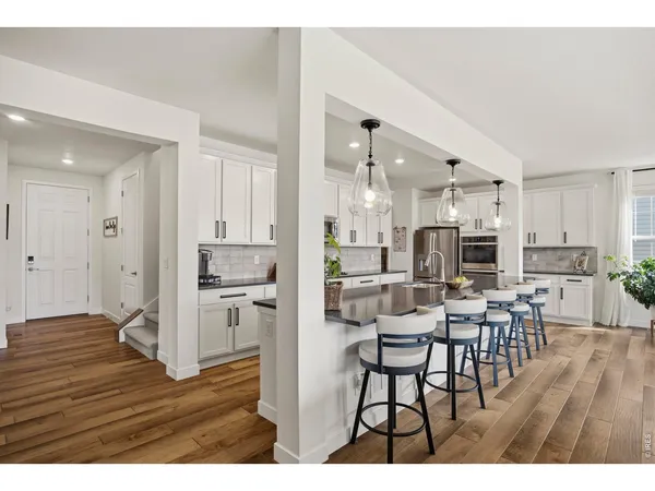 a open kitchen with stainless steel appliances kitchen island a refrigerator and a dining table