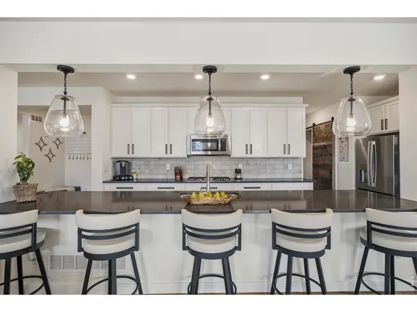 a kitchen with a sink and chairs