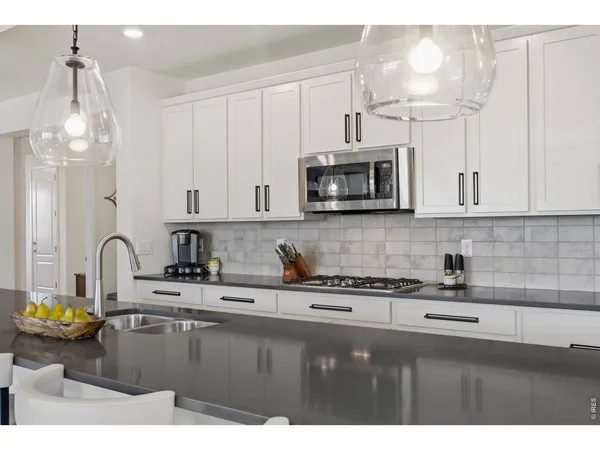 a kitchen with a sink a stove and cabinets