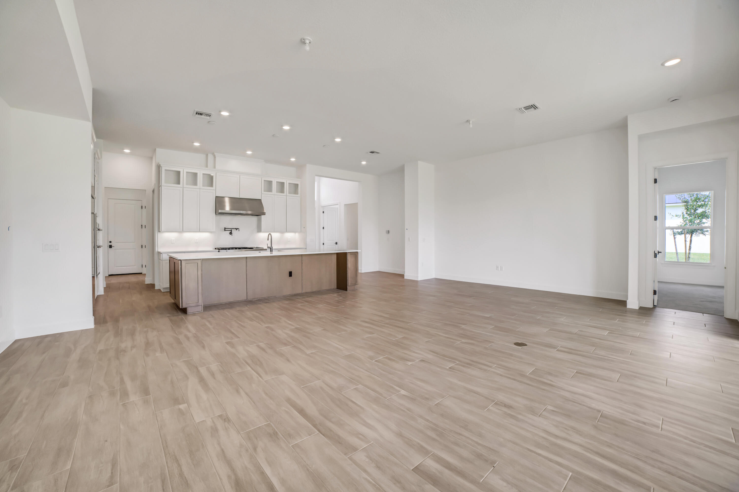 20161 Southeast Bridgewater Drive Jupiter, FL 33458 - Photo 11 of 50 a view of a kitchen with kitchen island a sink wooden floor and a stove top oven