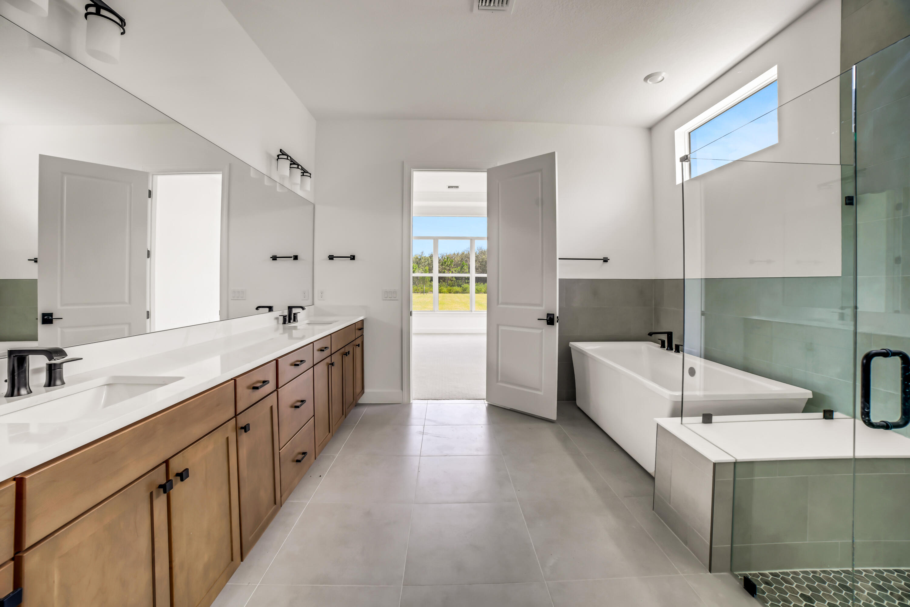 20161 Southeast Bridgewater Drive Jupiter, FL 33458 - Photo 27 of 50 a large white bathroom with a granite countertop double vanity sink a bathtub and mirror