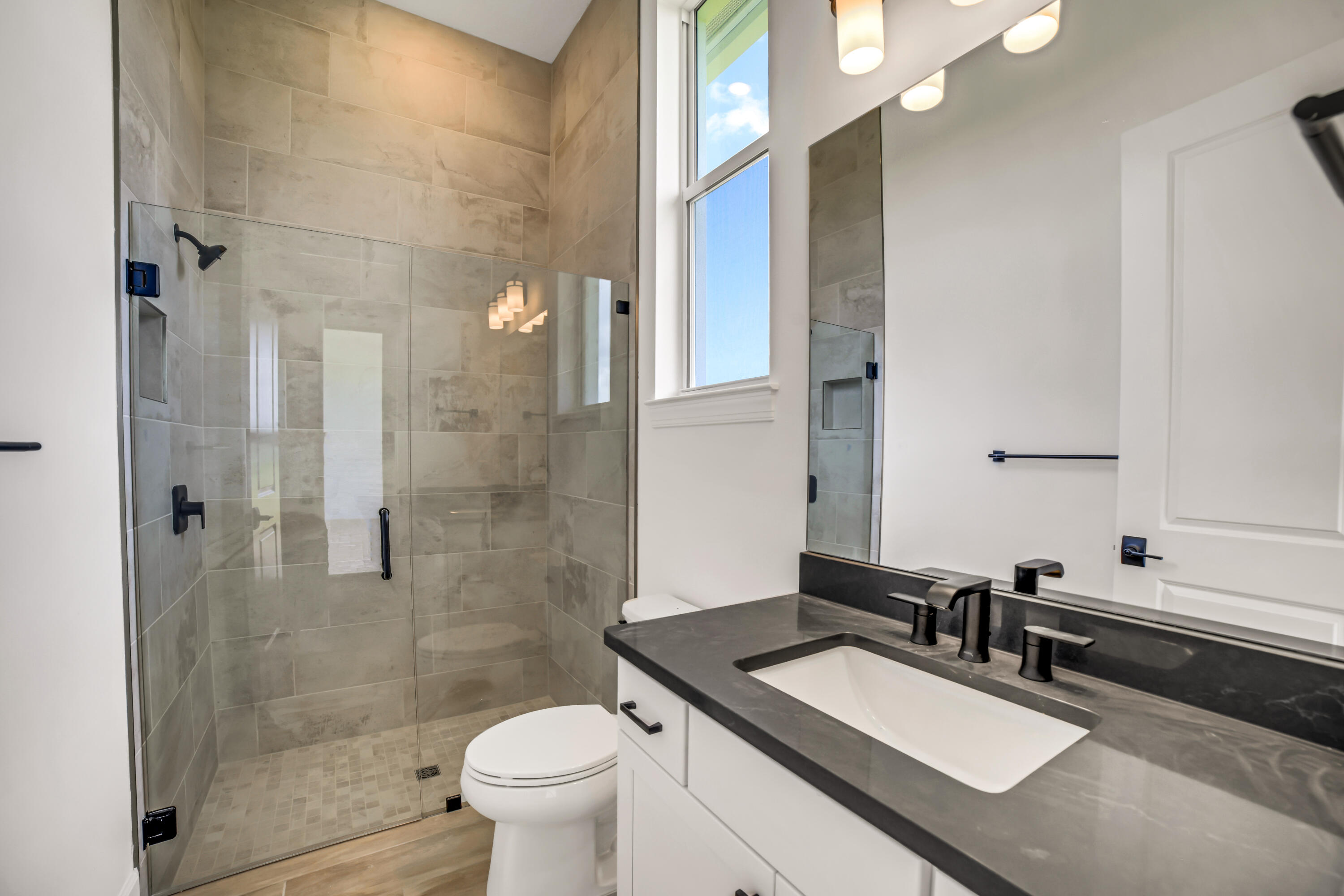 20161 Southeast Bridgewater Drive Jupiter, FL 33458 - Photo 35 of 50 a bathroom with a sink toilet a mirror and shower