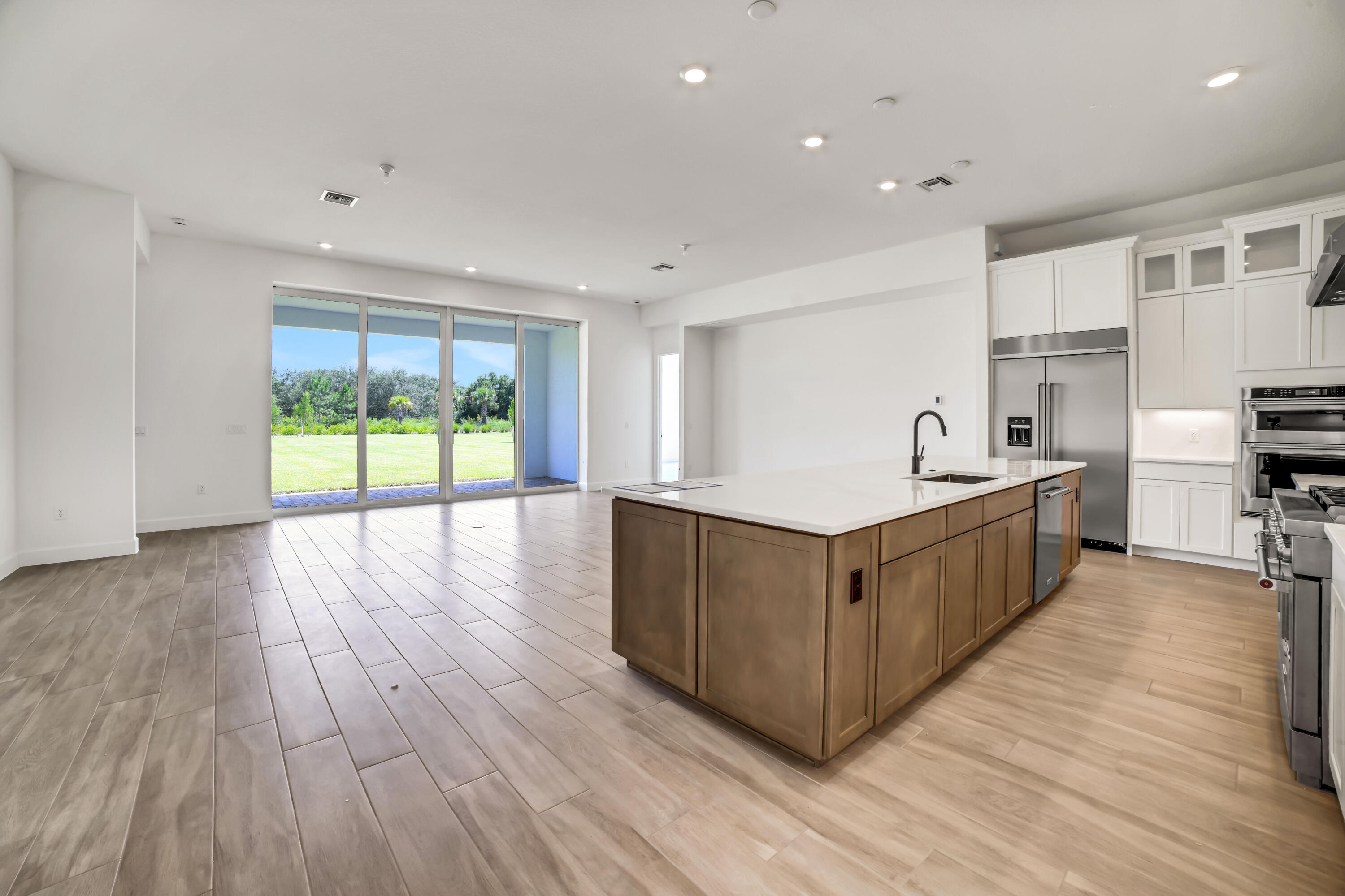 20161 Southeast Bridgewater Drive Jupiter, FL 33458 - Photo 4 of 50 a kitchen with stainless steel appliances granite countertop a large counter top a wooden floors and a large window